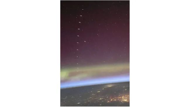 ISS ASTRONAUT CAPTURES AMAZING VIDEO OF SPACEX STARLINK SATELLITE TRAIN CRUISING ABOVE AURORAS